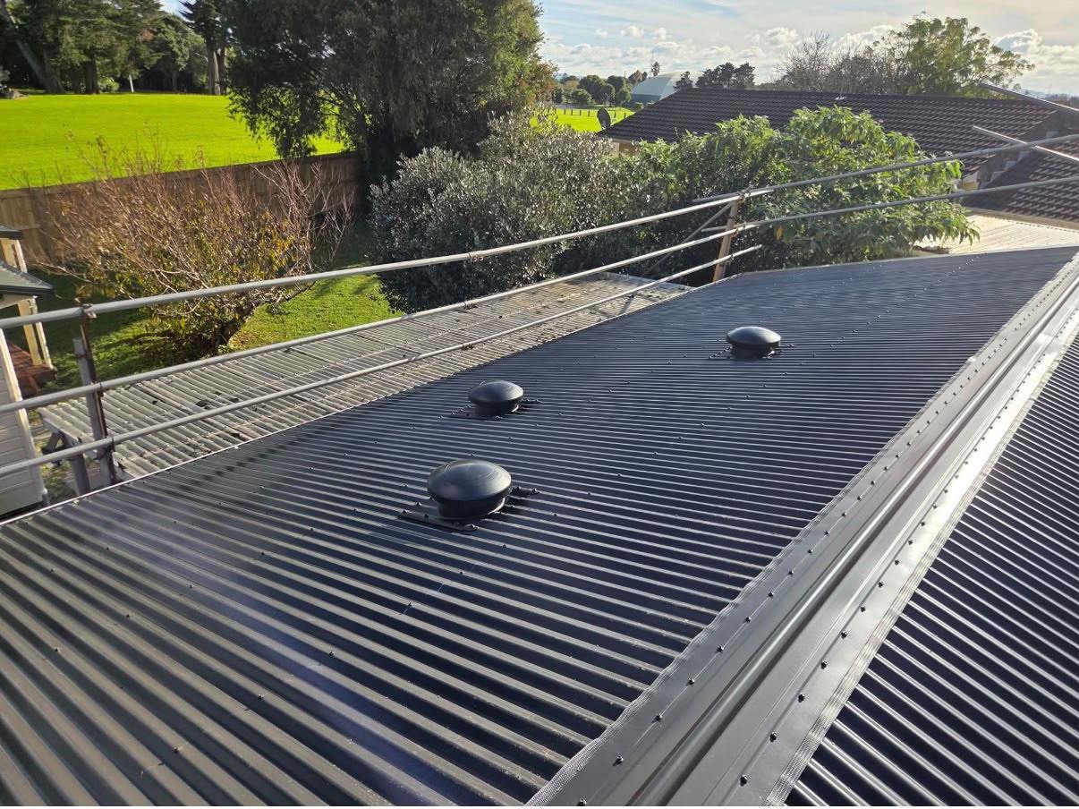 The same roof replaced in dark long-run roofing with new roof vents fitted