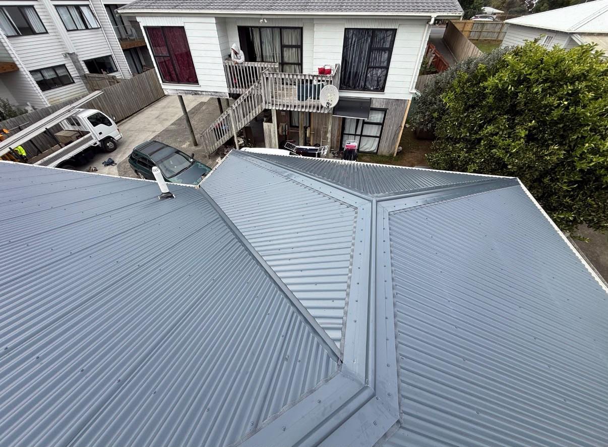 The same home finished in light grey long-run roofing, seen from above the ridge