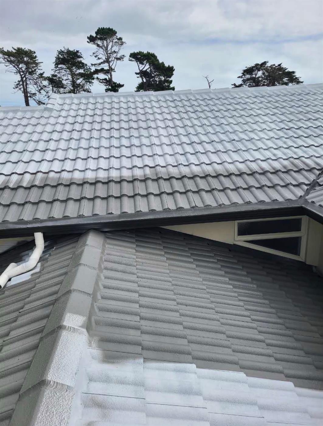 Two adjoining roof sections after restoration, the darker upper roof meeting the lighter lower one